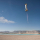 A Blue Origin New Shepard booster returning to the ground after a test flight,
